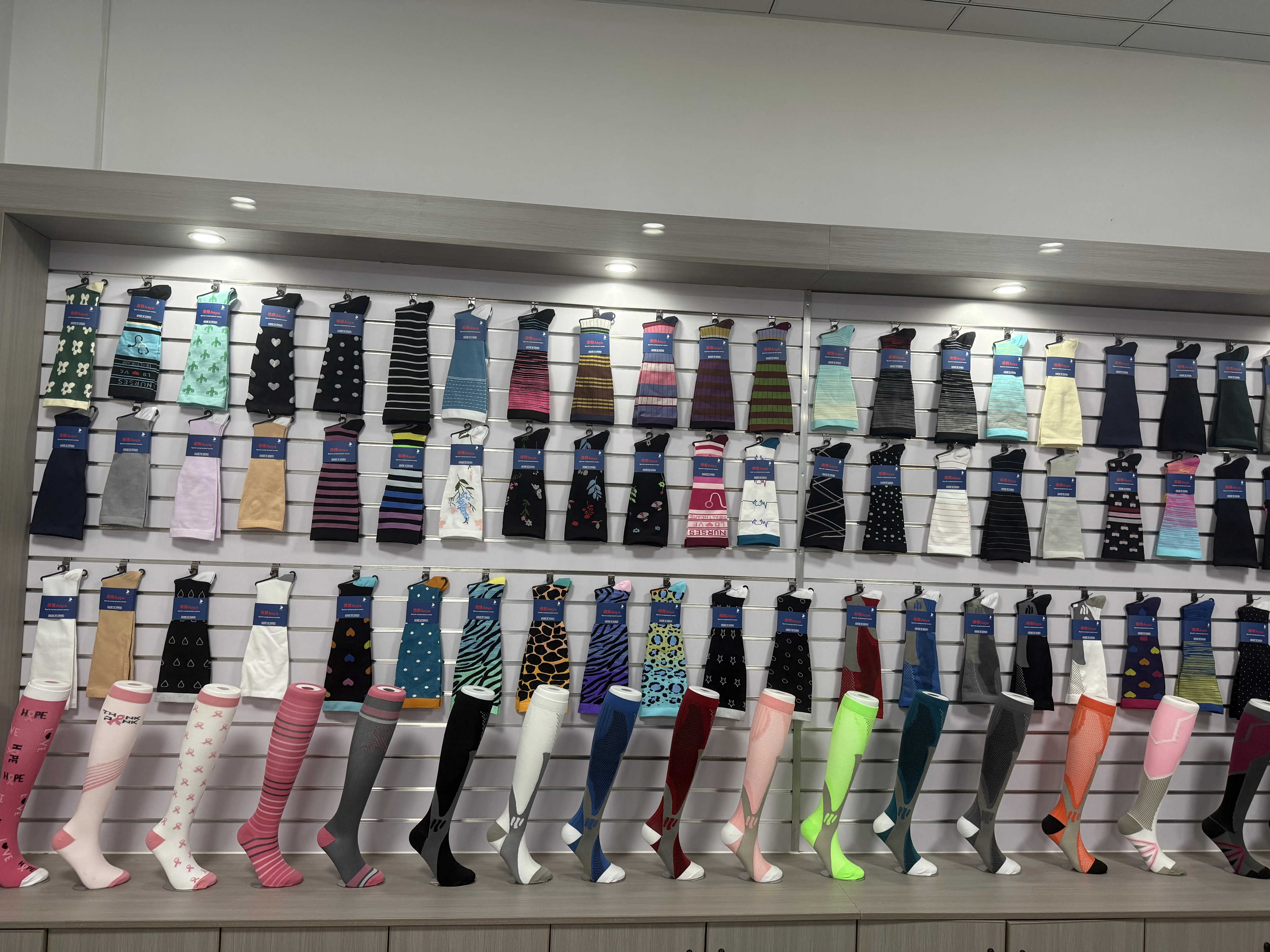 Compression socks factory sample wall with solid colors and printed styles